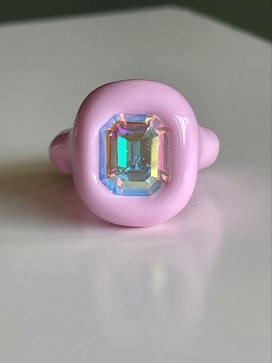 Pink ring with a colorful gemstone on a white background